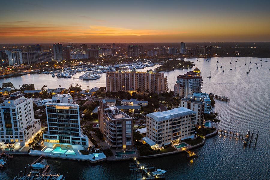 Contact Us - Aerial View of Sarasota, Florida Buildings at Night, Lights Glowing on the Water